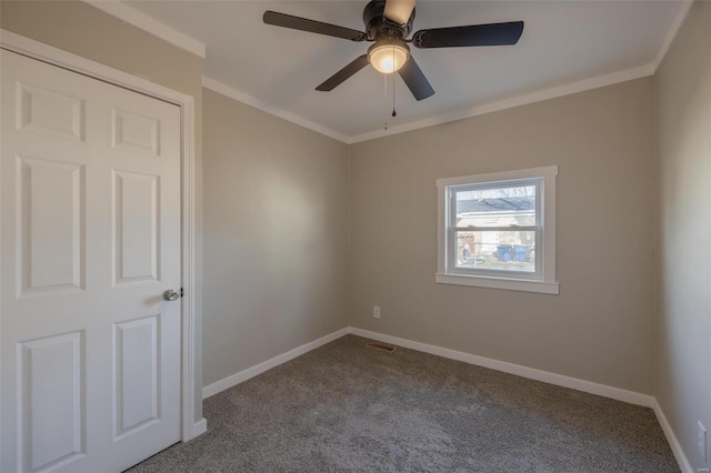 carpeted empty room with ceiling fan and ornamental molding