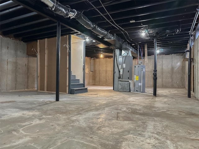 basement featuring heating unit, electric water heater, and electric panel