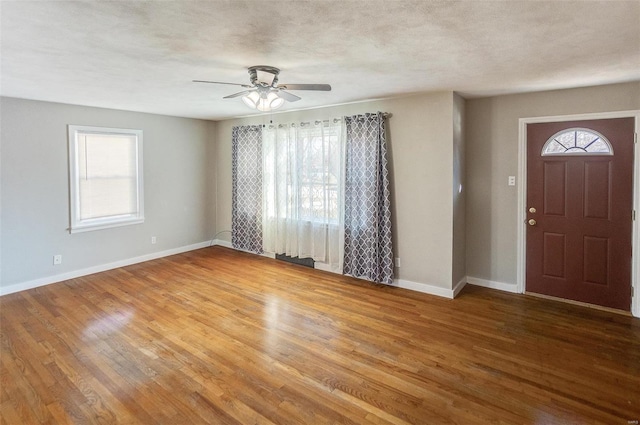 entrance foyer featuring wood-type flooring, a textured ceiling, and ceiling fan