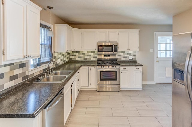 kitchen with appliances with stainless steel finishes, backsplash, white cabinetry, and sink