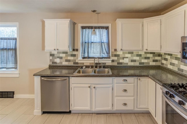 kitchen featuring white cabinets, appliances with stainless steel finishes, tasteful backsplash, and sink