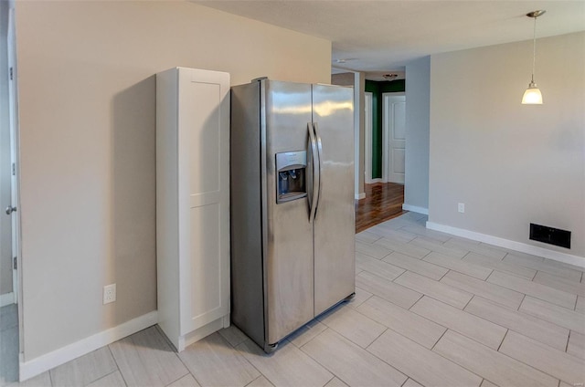 kitchen featuring stainless steel fridge and pendant lighting