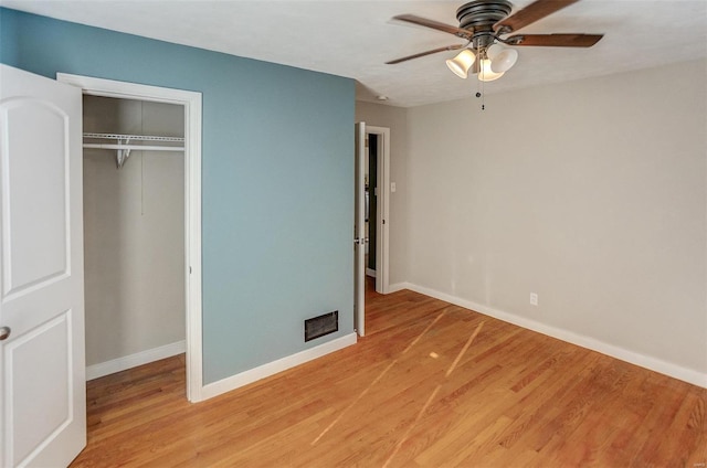 unfurnished bedroom featuring ceiling fan, wood-type flooring, and a closet