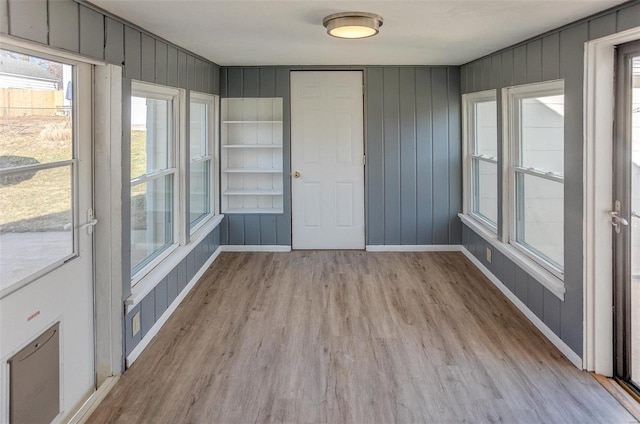 interior space with light wood-type flooring and wooden walls