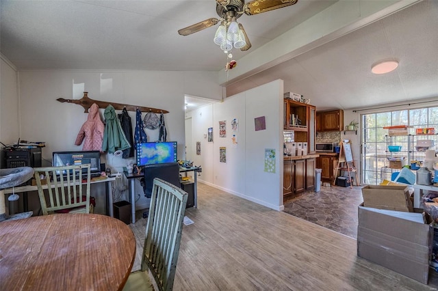 kitchen with decorative backsplash, a textured ceiling, ceiling fan, lofted ceiling with beams, and hardwood / wood-style floors