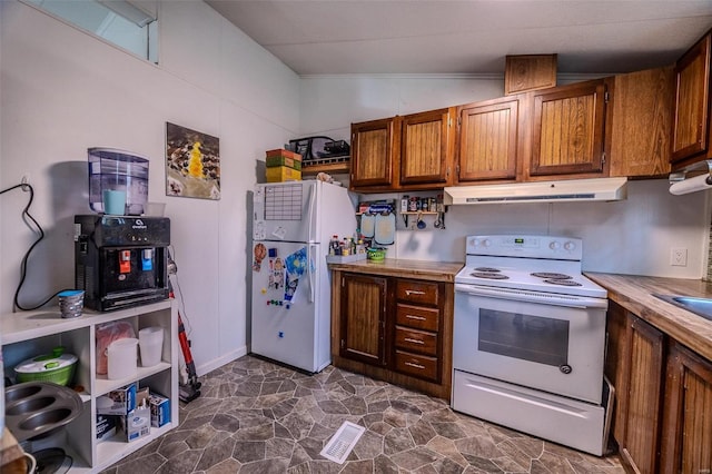 kitchen with white appliances and vaulted ceiling