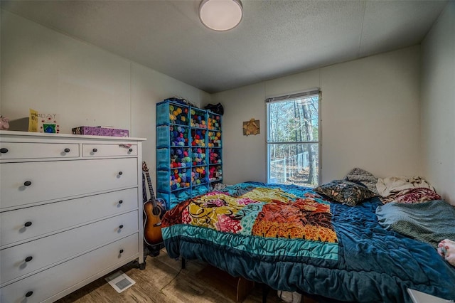 bedroom featuring light wood-type flooring and a textured ceiling