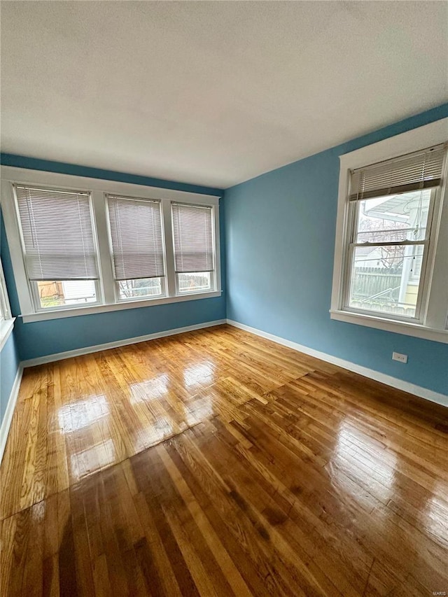 unfurnished room with wood-type flooring and a textured ceiling