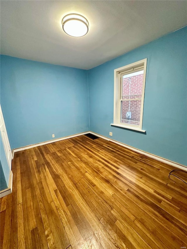 spare room featuring wood-type flooring