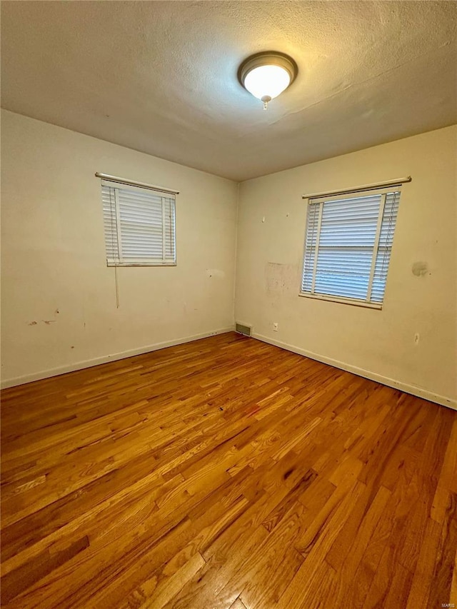 spare room with hardwood / wood-style flooring and a textured ceiling