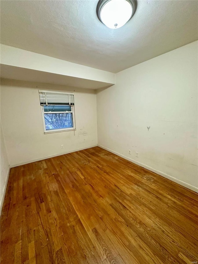 basement featuring hardwood / wood-style floors and a textured ceiling