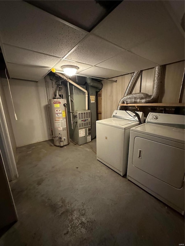 basement with washer and dryer, a paneled ceiling, gas water heater, and heating unit