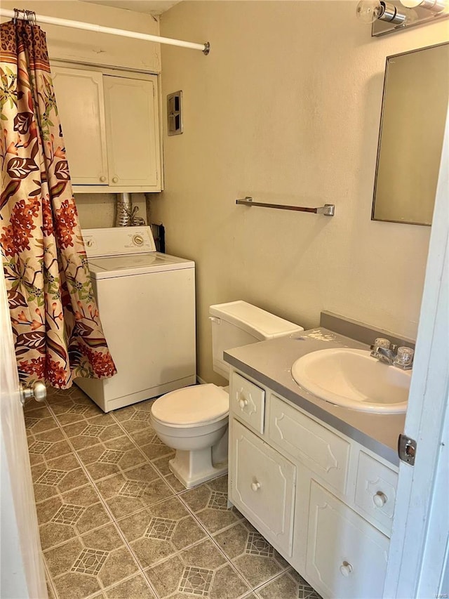 bathroom with toilet, washer / dryer, vanity, and tile patterned floors