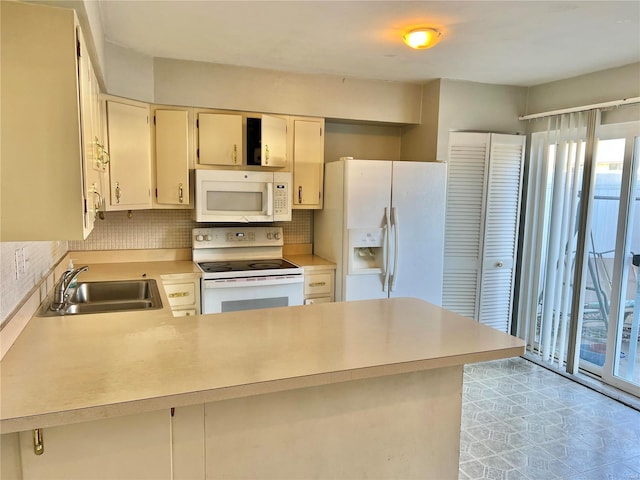 kitchen featuring sink, backsplash, kitchen peninsula, cream cabinets, and white appliances