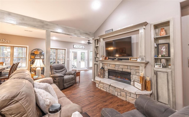 living room with french doors, ceiling fan, high vaulted ceiling, dark hardwood / wood-style floors, and a stone fireplace