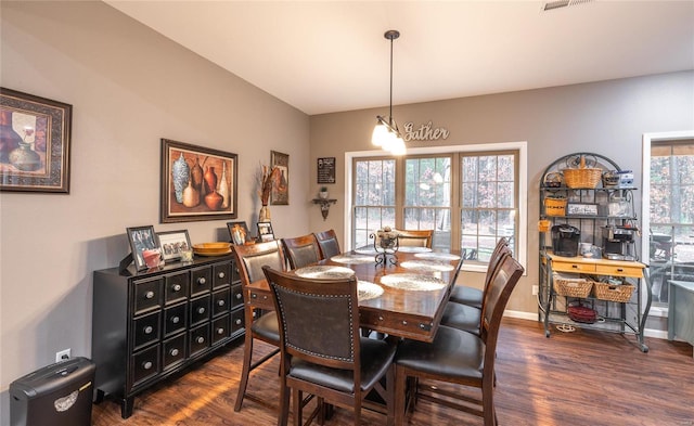 dining room featuring dark hardwood / wood-style floors, plenty of natural light, and a notable chandelier