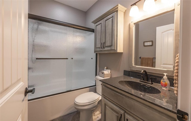 full bathroom featuring combined bath / shower with glass door, tile patterned floors, vanity, and toilet