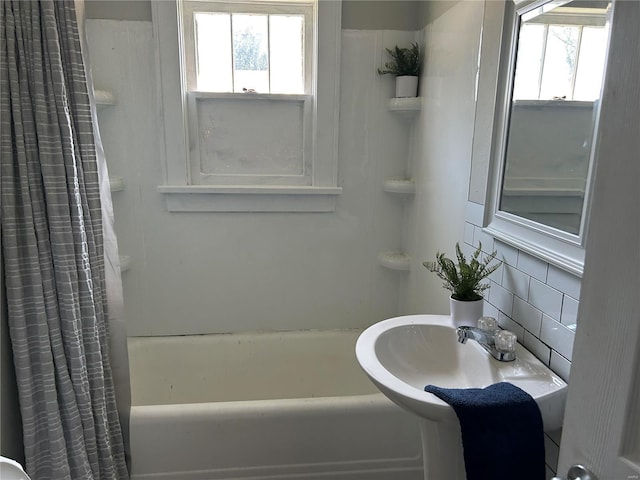 bathroom with shower / bath combination with curtain, sink, and tasteful backsplash