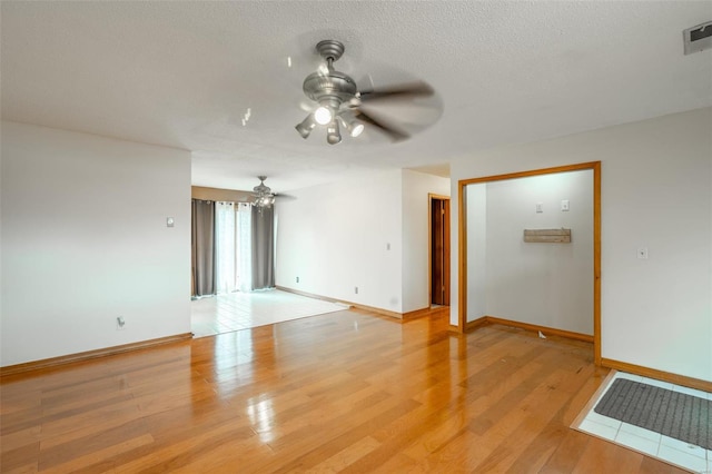 unfurnished room featuring ceiling fan, a textured ceiling, and light hardwood / wood-style flooring