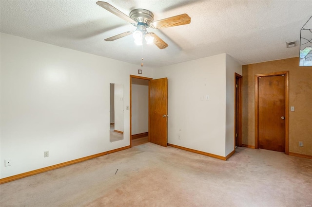 spare room with ceiling fan, light colored carpet, and a textured ceiling