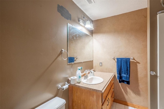 bathroom featuring vanity, tile patterned floors, a textured ceiling, and toilet