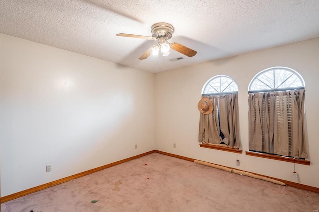 empty room with light carpet, a textured ceiling, and ceiling fan