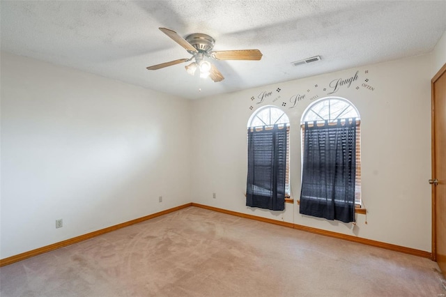 carpeted spare room with ceiling fan and a textured ceiling