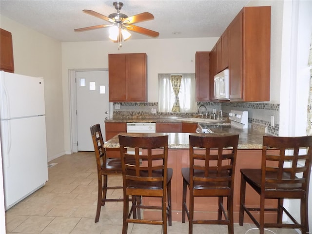 kitchen with decorative backsplash, white appliances, kitchen peninsula, and ceiling fan