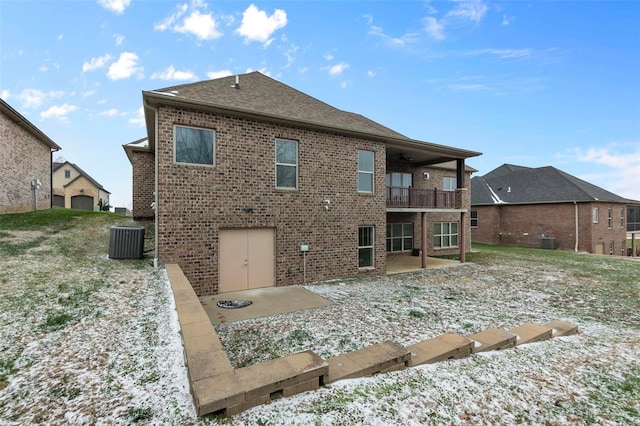 snow covered property with cooling unit, a patio area, and a balcony