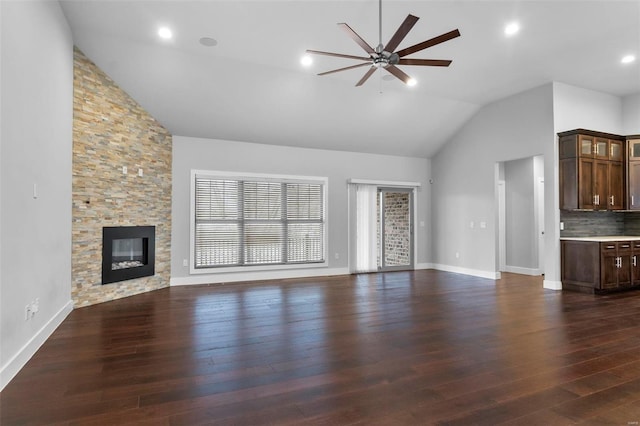 unfurnished living room featuring ceiling fan, a fireplace, dark wood-type flooring, and lofted ceiling