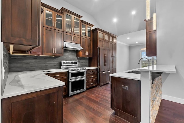 kitchen featuring light stone countertops, decorative backsplash, sink, double oven range, and built in fridge