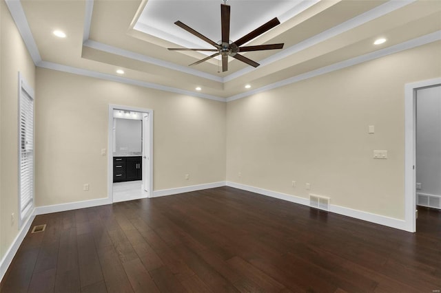 unfurnished room with a raised ceiling, ceiling fan, dark hardwood / wood-style floors, and ornamental molding