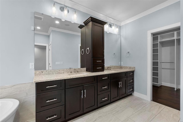 bathroom featuring a bathing tub, vanity, and ornamental molding