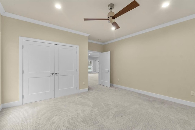 unfurnished bedroom with a closet, light colored carpet, ceiling fan, and ornamental molding