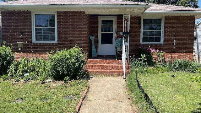 view of exterior entry with a yard