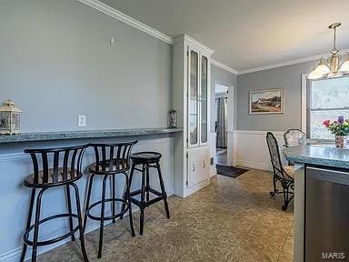 dining area with ornamental molding and a notable chandelier