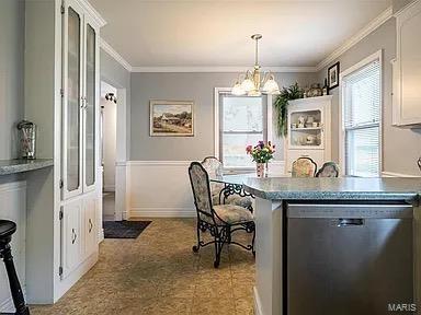 dining room with ornamental molding, a wealth of natural light, and an inviting chandelier