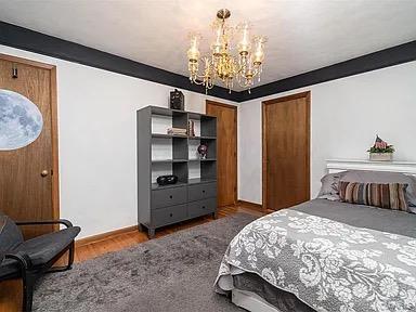 bedroom with a notable chandelier and dark hardwood / wood-style flooring