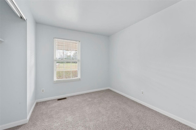 spare room featuring light colored carpet