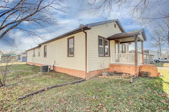 view of property exterior featuring a yard, cooling unit, and covered porch