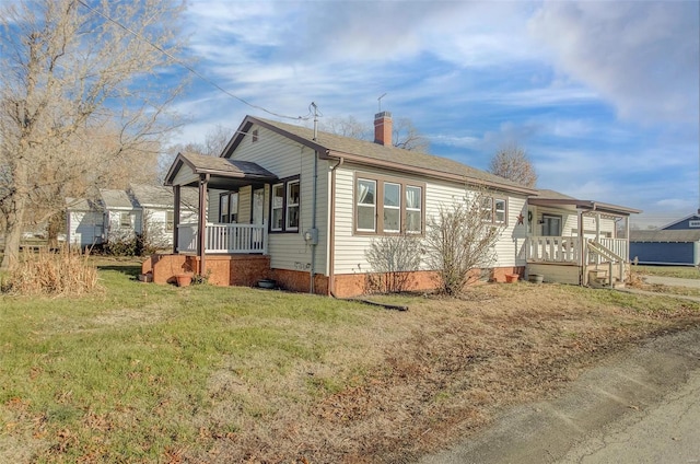 view of side of property with a yard and a porch