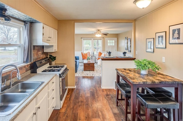 kitchen featuring white cabinets, ornamental molding, dark wood-type flooring, sink, and white range with gas stovetop