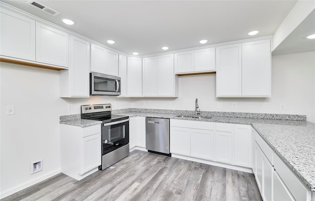 kitchen with stainless steel appliances, sink, and white cabinets