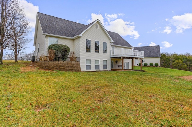 rear view of house featuring a deck and a lawn