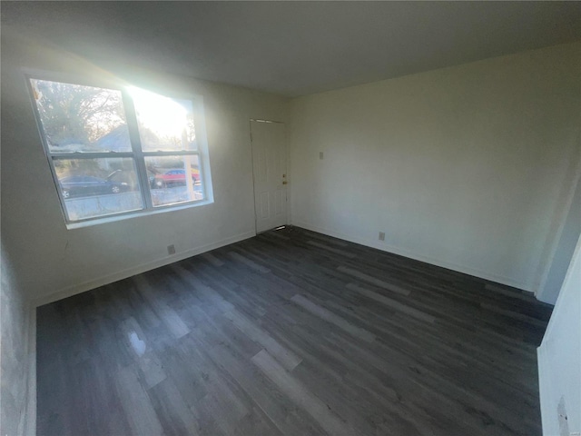 spare room with dark hardwood / wood-style flooring