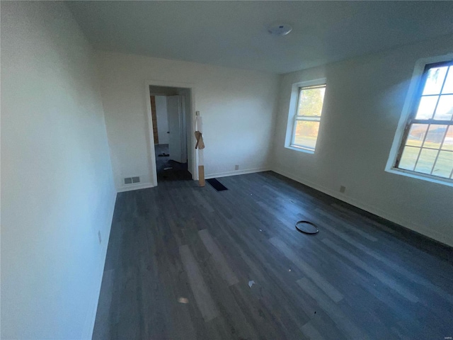 empty room featuring dark hardwood / wood-style floors and plenty of natural light