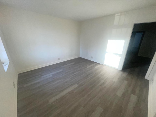 unfurnished room with dark hardwood / wood-style floors and a healthy amount of sunlight