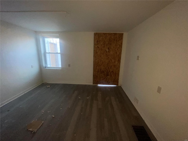 unfurnished room with dark hardwood / wood-style flooring