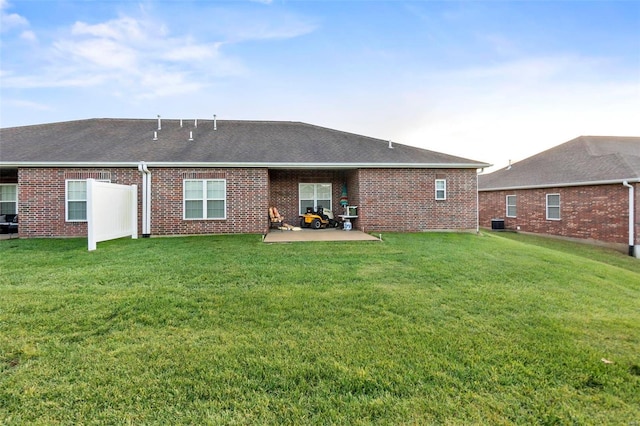 back of property featuring central AC, a patio area, and a lawn