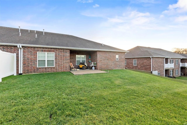 back of property featuring a lawn and a patio